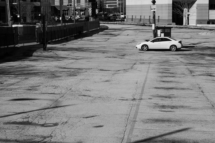 Car sits in an empty, closed off, parking lot. This lot will be part of a new highrise building that begins construction soon. West Loop, Chicago